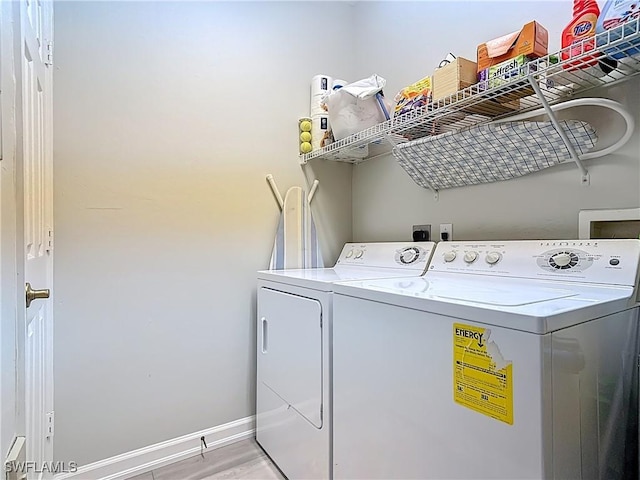 laundry area featuring light wood-type flooring, baseboards, laundry area, and washer and clothes dryer