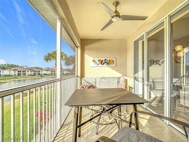 balcony with a sunroom, ceiling fan, and a water view