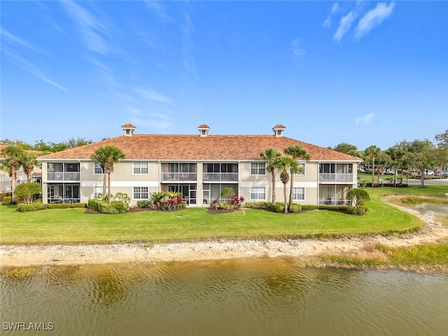 back of property featuring a lawn and a water view