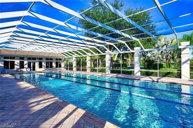 community pool with glass enclosure and a patio