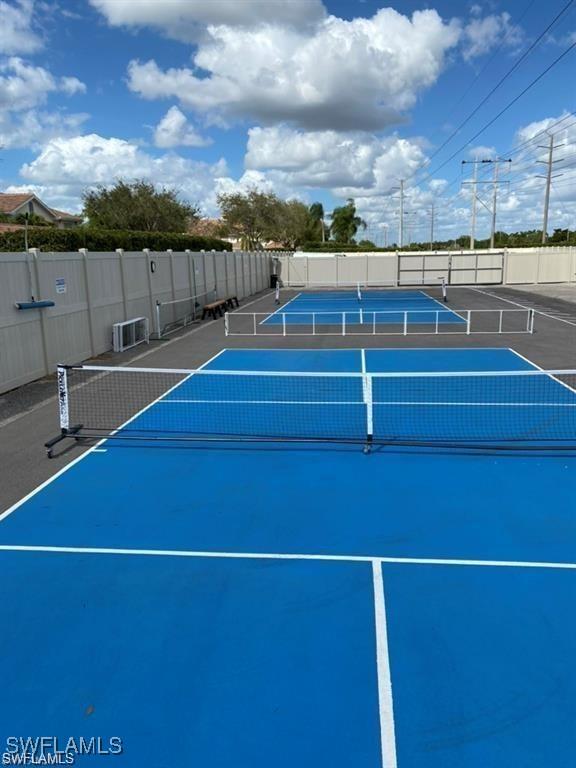 view of tennis court featuring fence