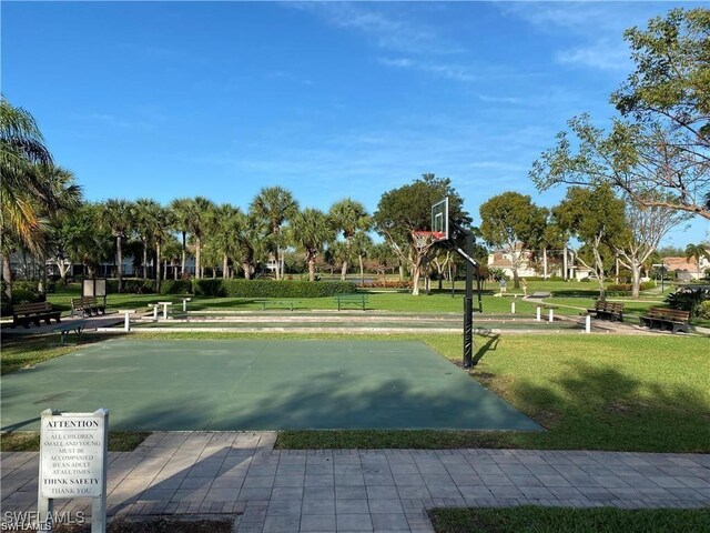 view of property's community with community basketball court and a lawn