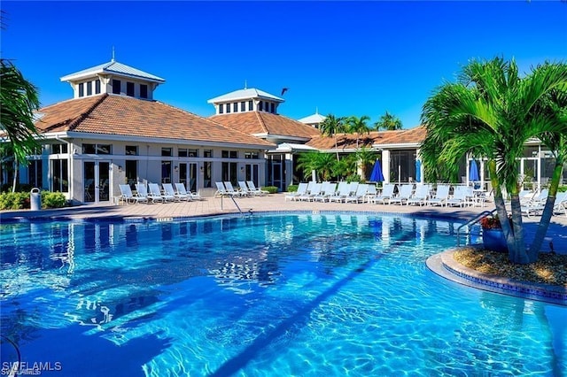 community pool with a patio area and fence