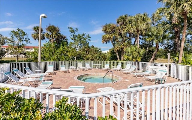 view of swimming pool with a patio, fence, and a hot tub