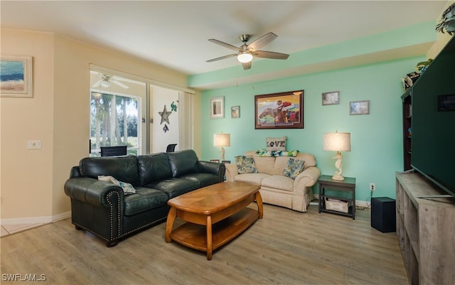 living area with ceiling fan, light wood-style flooring, and baseboards