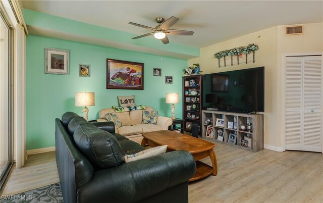 living area featuring ceiling fan, wood finished floors, visible vents, and baseboards