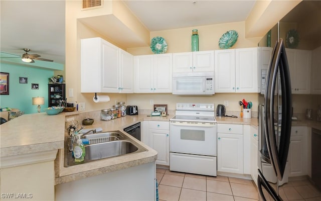 kitchen with white appliances, visible vents, a peninsula, light countertops, and a sink