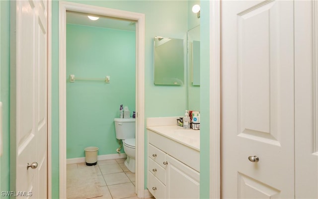 bathroom with baseboards, vanity, toilet, and tile patterned floors