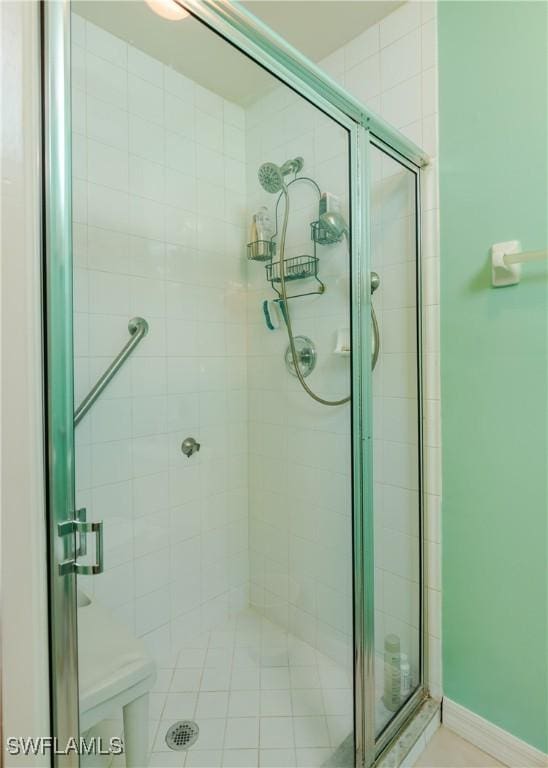 full bath with a stall shower and baseboards