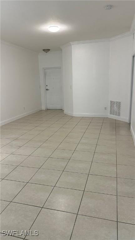 8484 Bernwood Cove Loop Unit 1301, Fort Myers, FL 33966 - empty room with light tile patterned floors, a smoke detector, baseboards, and ornamental molding