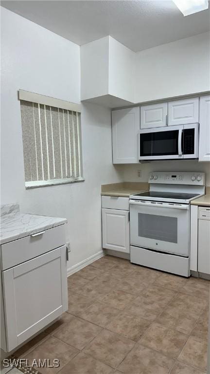 8484 Bernwood Cove Loop Unit 1301, Fort Myers, FL 33966 - kitchen with white electric stove, white cabinets, and baseboards