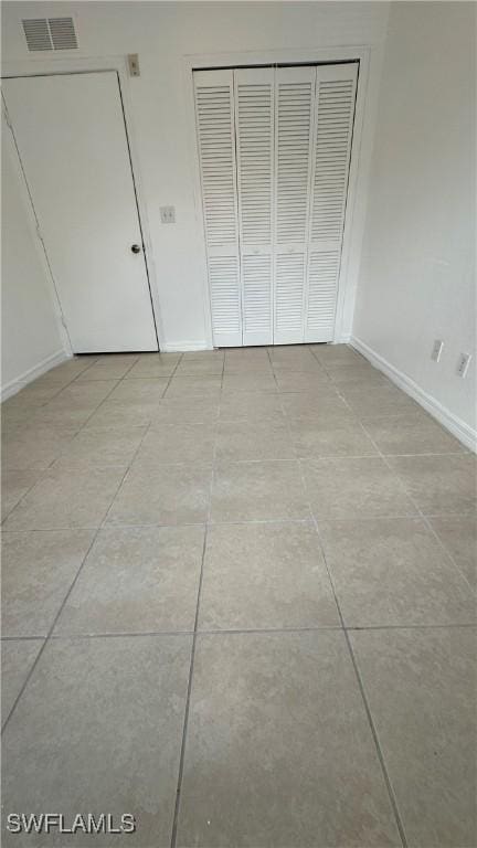 8484 Bernwood Cove Loop Unit 1301, Fort Myers, FL 33966 - unfurnished bedroom featuring a closet, baseboards, and light tile patterned floors