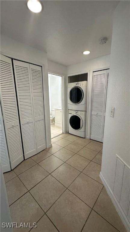 8484 Bernwood Cove Loop Unit 1301, Fort Myers, FL 33966 - washroom featuring stacked washer / drying machine, light tile patterned flooring, and baseboards