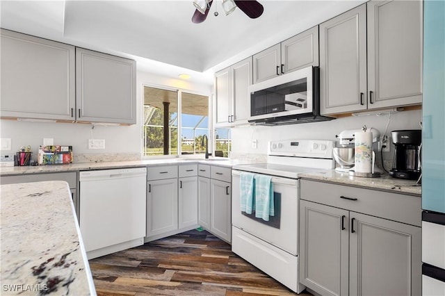 kitchen with gray cabinetry, dark wood-type flooring, a sink, ceiling fan, and white appliances