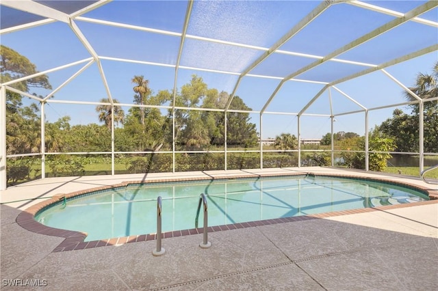 pool featuring glass enclosure and a patio