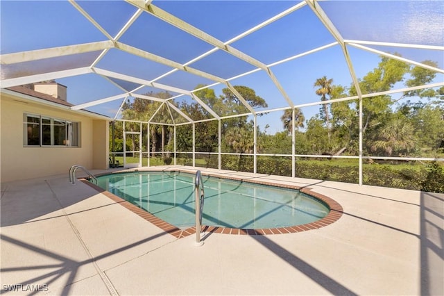 outdoor pool featuring a patio area and glass enclosure