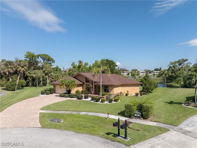 view of front of house with a front yard, decorative driveway, and an attached garage