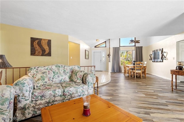 living area featuring ceiling fan, vaulted ceiling, baseboards, and wood finished floors