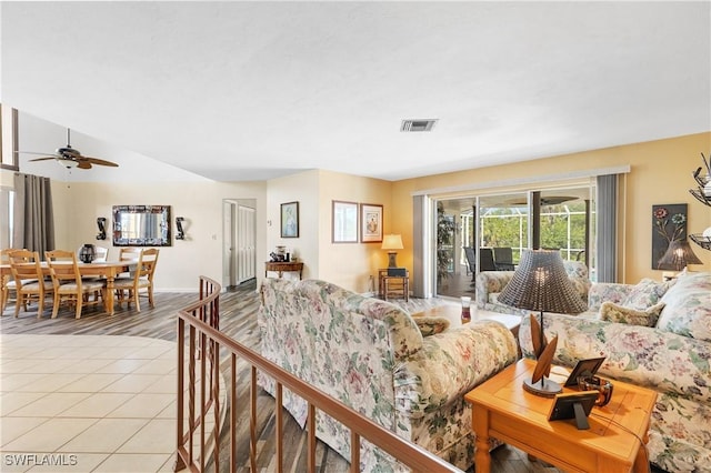 living room featuring light tile patterned floors, ceiling fan, and visible vents