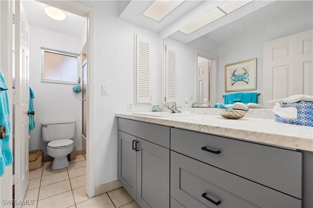 bathroom with toilet, tile patterned flooring, vanity, and baseboards