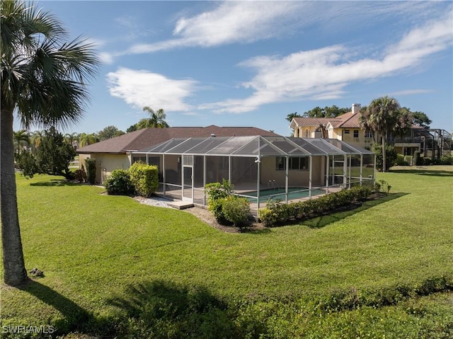 back of property featuring glass enclosure, a yard, and an outdoor pool