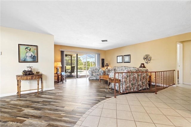 living area featuring visible vents, baseboards, and wood finished floors