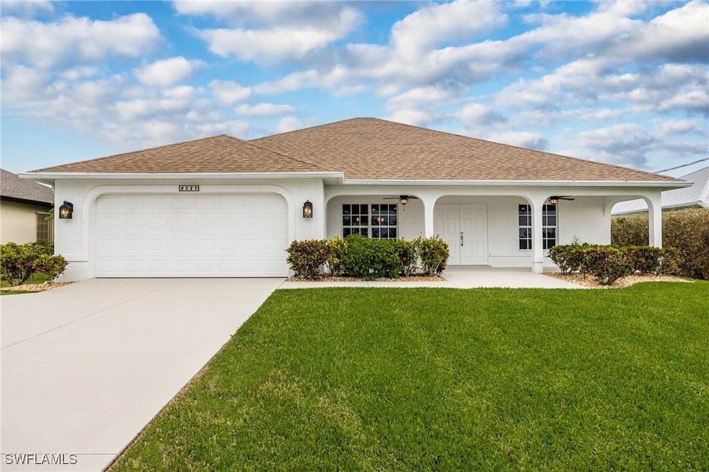 ranch-style house with a shingled roof, concrete driveway, an attached garage, a front yard, and stucco siding