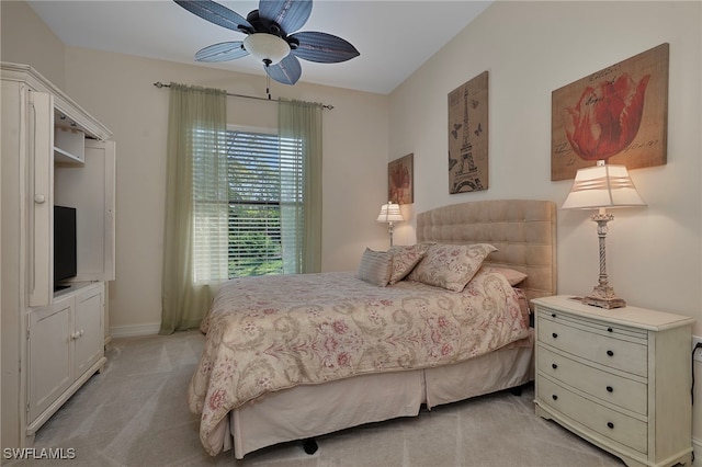 bedroom with light colored carpet, baseboards, and a ceiling fan