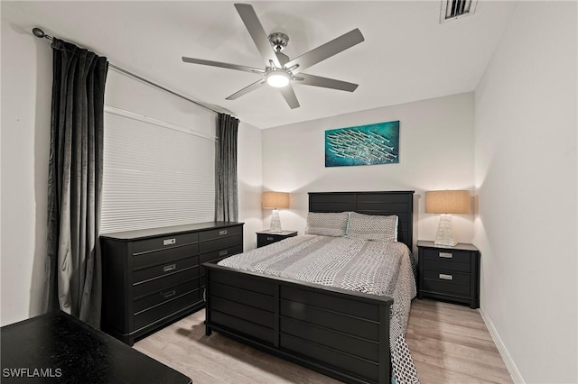 bedroom with light wood-style flooring, a ceiling fan, visible vents, and baseboards