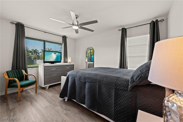 bedroom featuring light wood-style floors, baseboards, and a ceiling fan