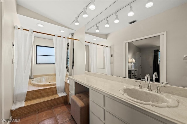 bathroom with visible vents, lofted ceiling, tile patterned flooring, vanity, and tiled tub