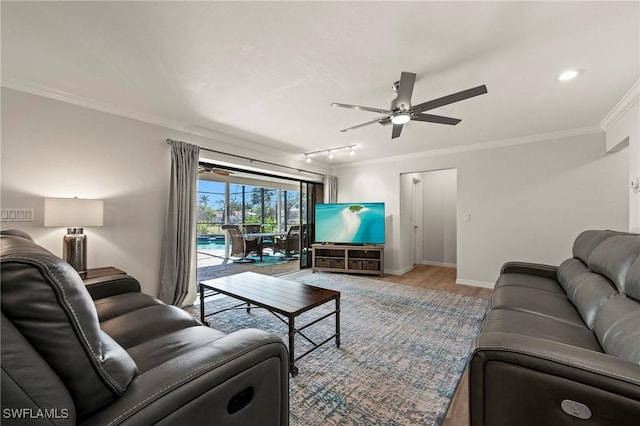 living room featuring ceiling fan, crown molding, wood finished floors, baseboards, and track lighting