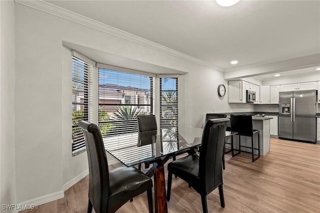 dining area with ornamental molding, recessed lighting, light wood-style flooring, and baseboards