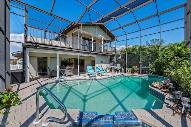 rear view of house with a balcony, a lanai, an outdoor pool, and a patio