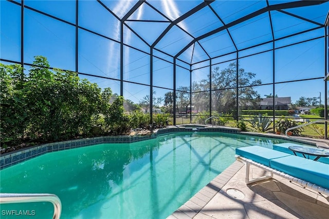 pool featuring a lanai, a patio area, and an in ground hot tub