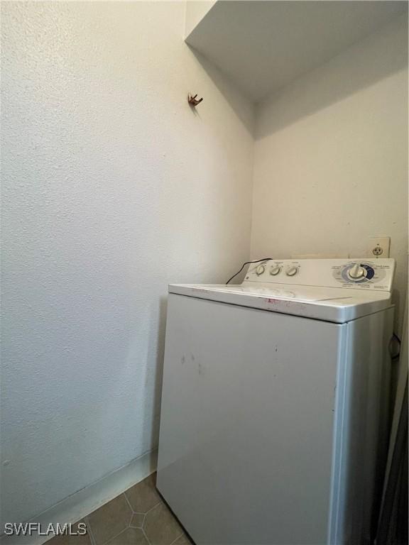 laundry area with washer / dryer, dark tile patterned floors, and laundry area