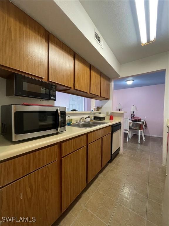 kitchen with visible vents, dishwashing machine, stainless steel microwave, light countertops, and black microwave