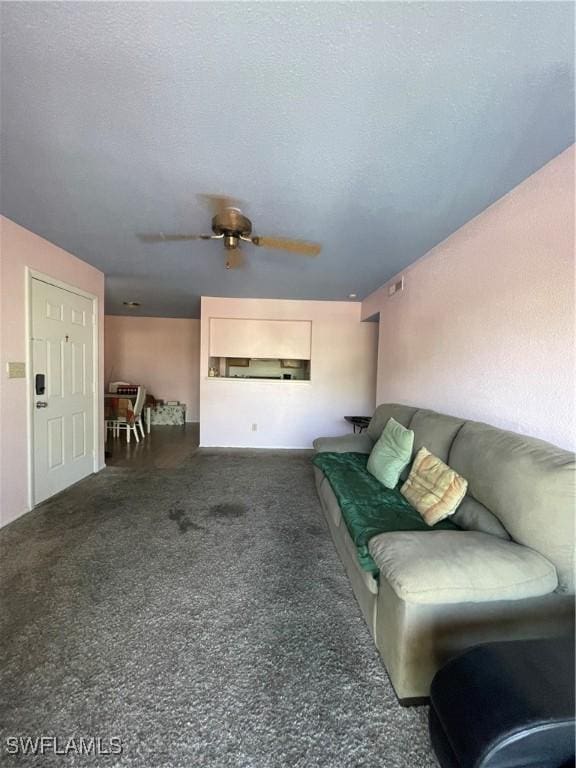 living area with a ceiling fan and a textured ceiling