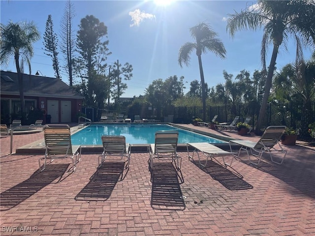 community pool featuring a patio and fence