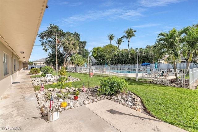 view of yard featuring a patio area, a community pool, and fence