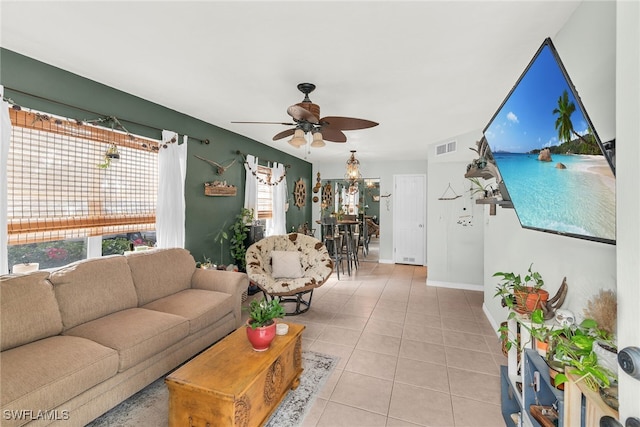 living area with visible vents, ceiling fan, baseboards, and light tile patterned flooring