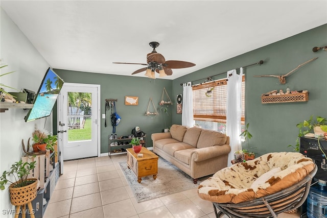 living area featuring a healthy amount of sunlight, tile patterned flooring, baseboards, and ceiling fan