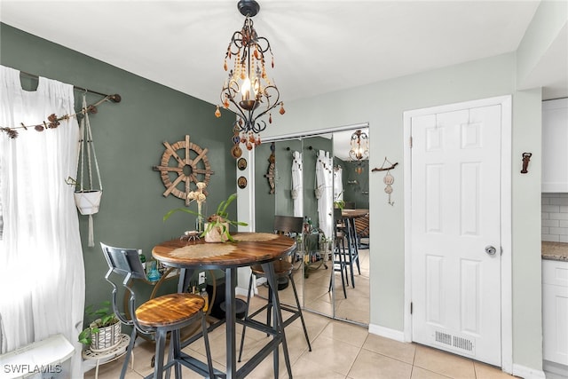 dining space with an inviting chandelier, light tile patterned floors, and visible vents