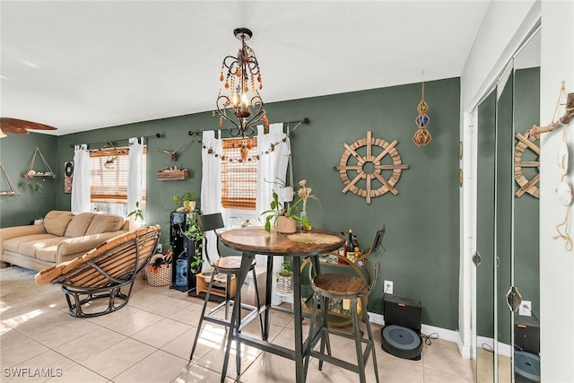 dining space featuring baseboards, an inviting chandelier, and tile patterned floors