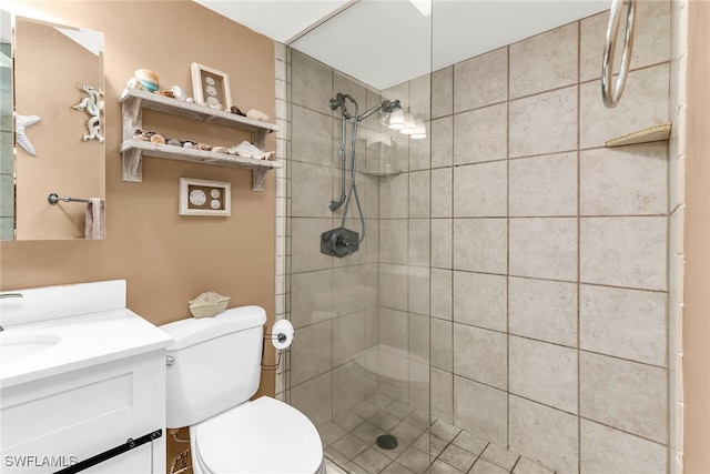 full bathroom featuring toilet, tiled shower, and vanity