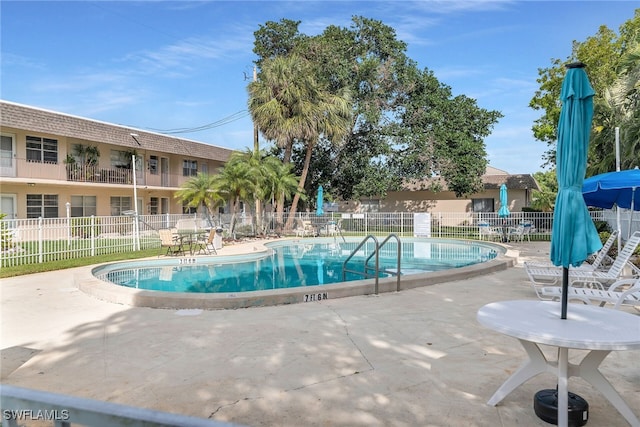 community pool with fence and a patio