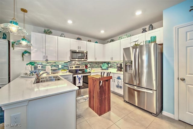 kitchen featuring tasteful backsplash, stainless steel appliances, a sink, and light countertops