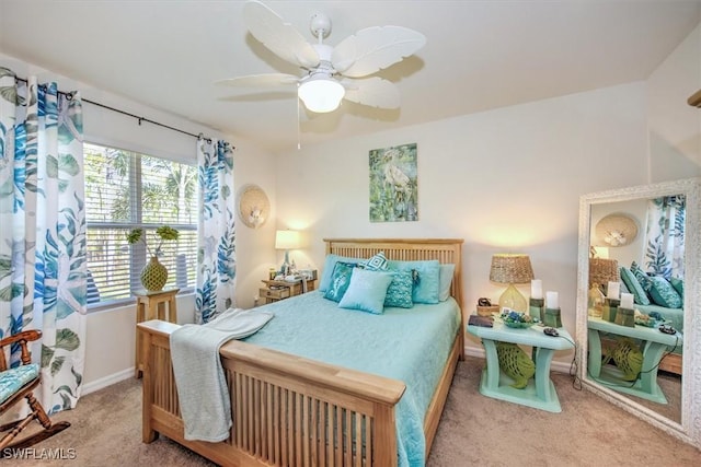 carpeted bedroom with ceiling fan and baseboards