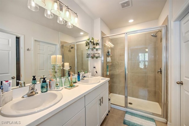 bathroom with tile patterned flooring, a shower stall, visible vents, and a sink