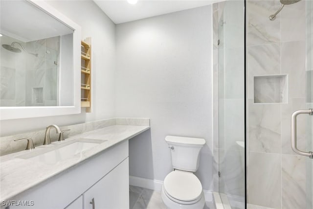 full bathroom with toilet, a stall shower, vanity, and baseboards